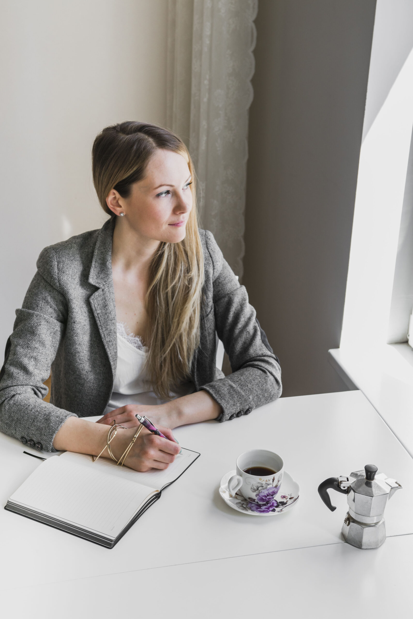 elegant woman writing looking out window